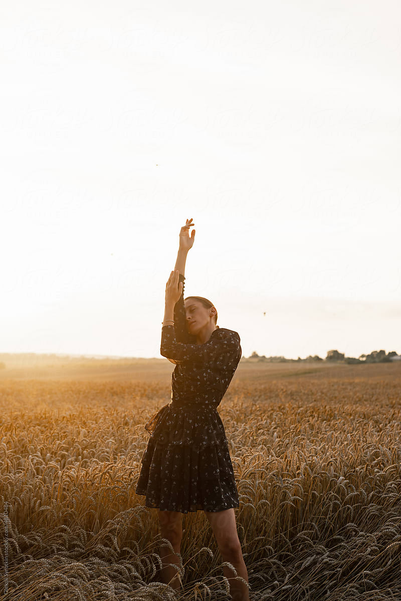 Woman in black dress posing among harvest