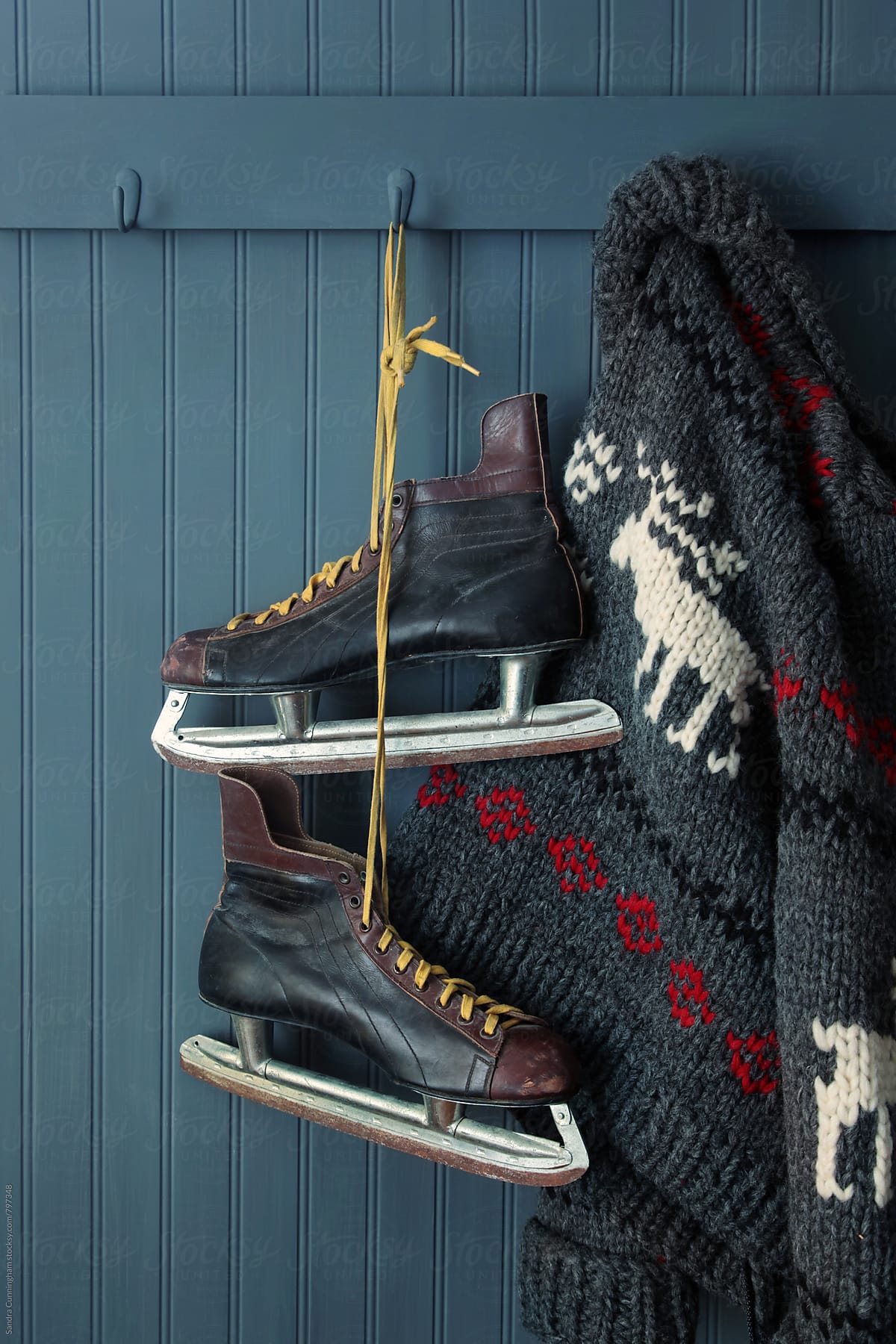 Men\'s vintage skates  and sweater hanging on hooks