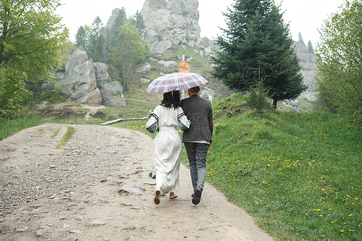 Lovely couple walking among spacious rocky mountain.