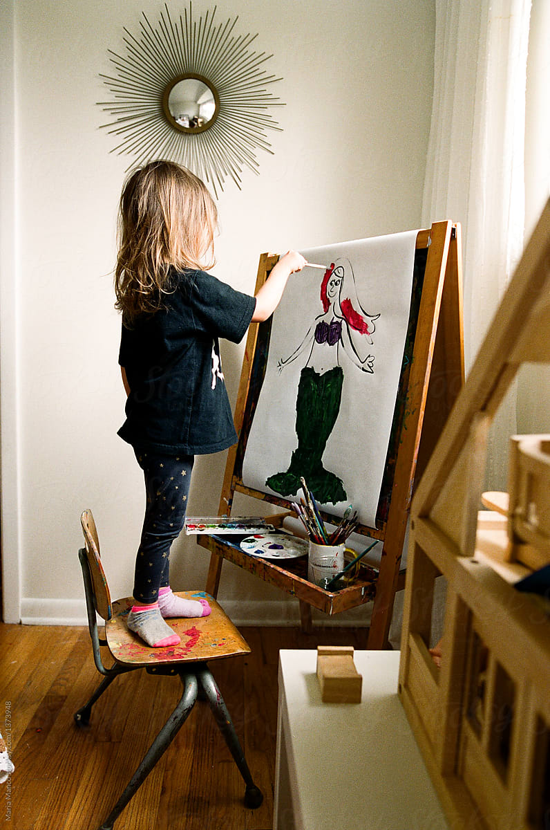 little girl painting at easel