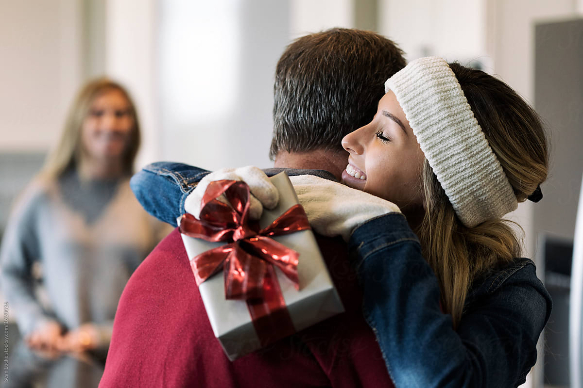 Home: Girl Returning Home Holds Gift And Hugs Dad