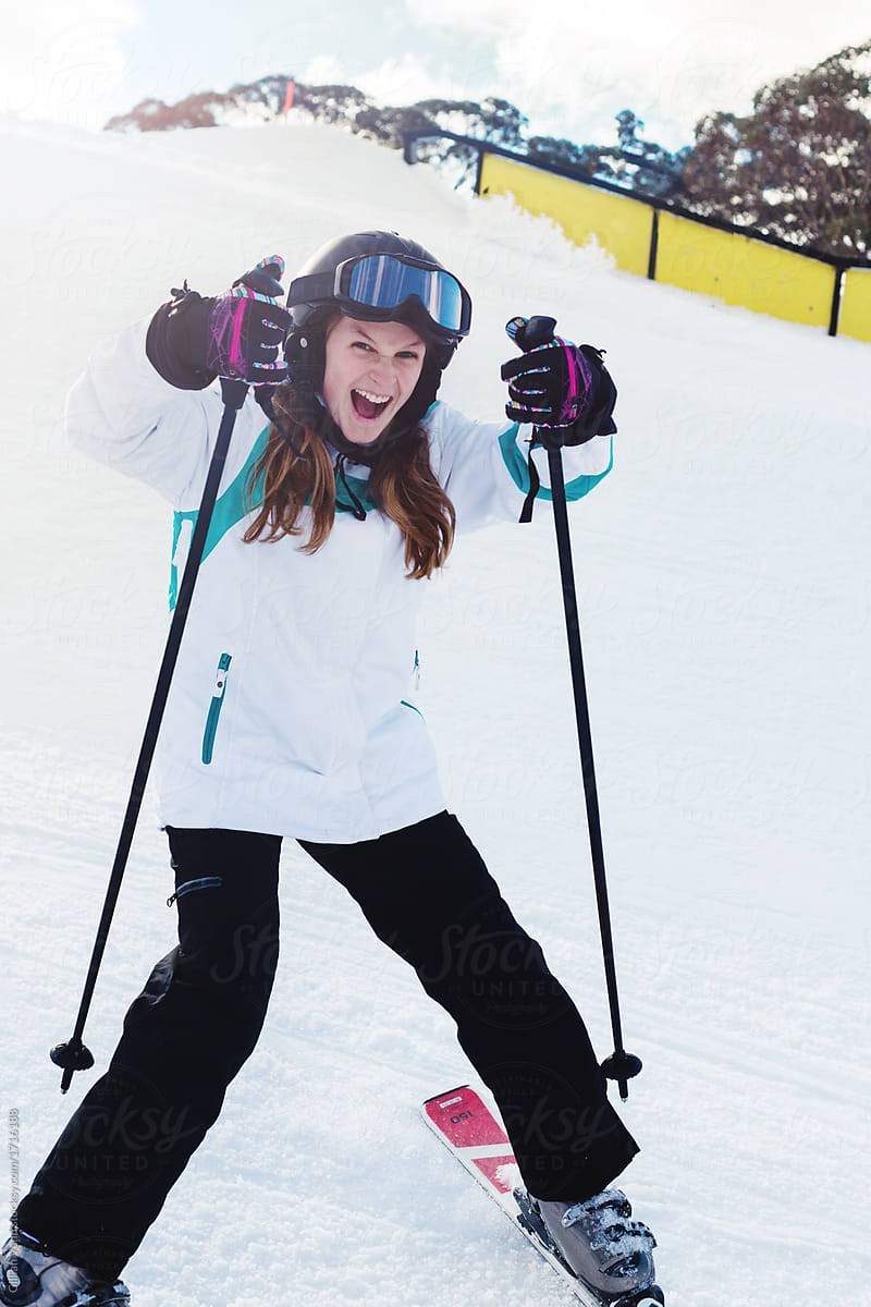teen girl pulling silly pose as she skis by