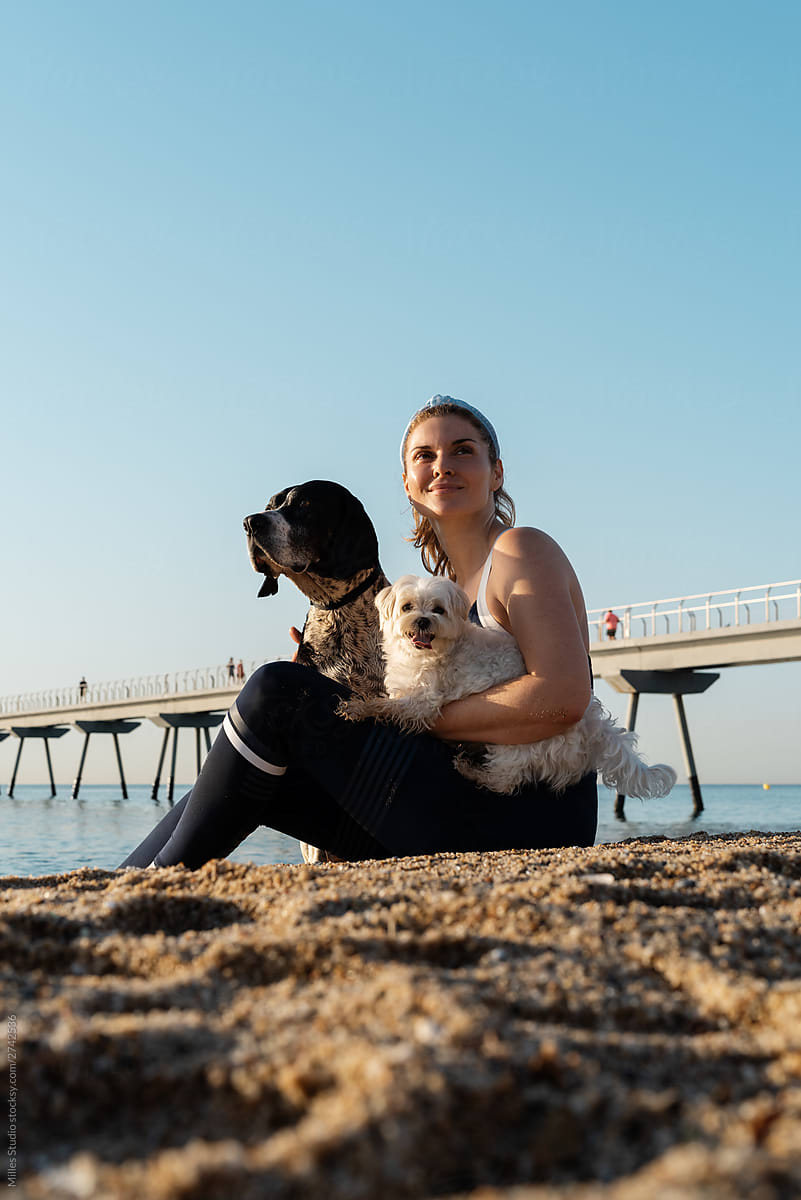 Happy female with dogs looking away on beach