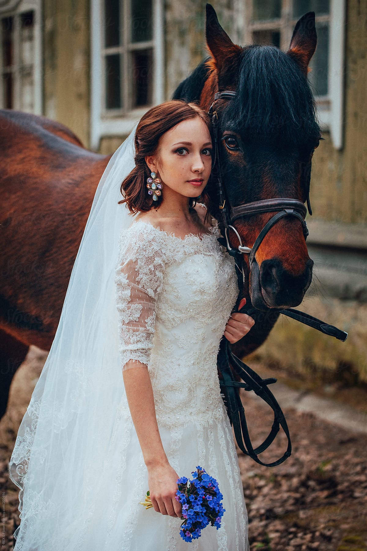 Bride standing near brown horse