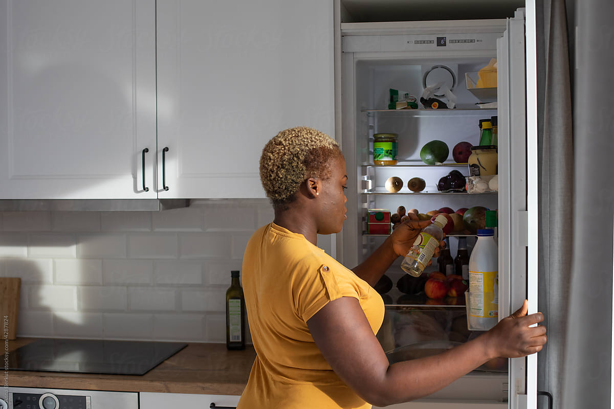 food in refrigerator, black woman in the kitchen at home