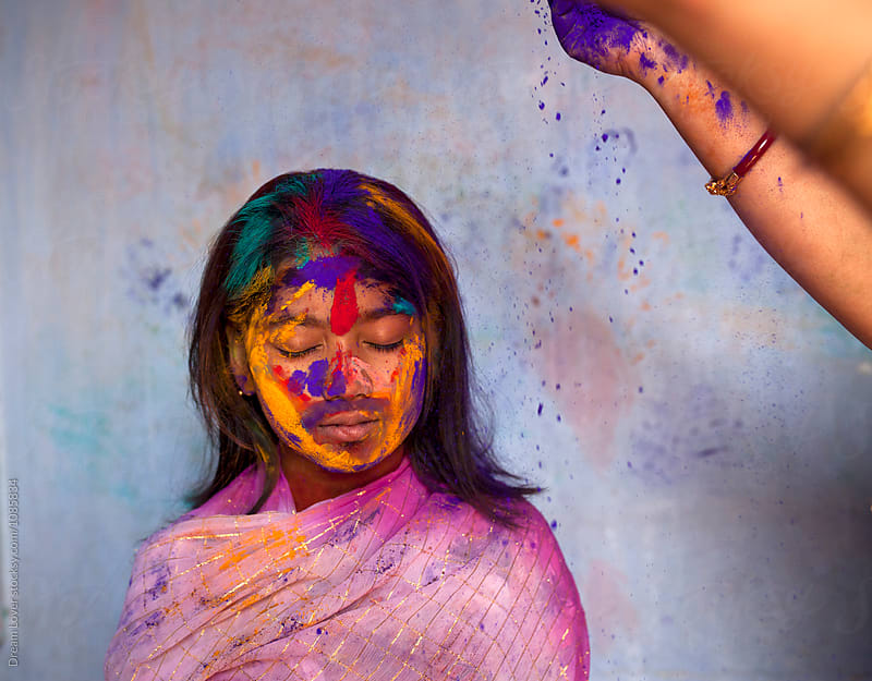 Mother givinf colorful spray powder to her daughter during Holi festival