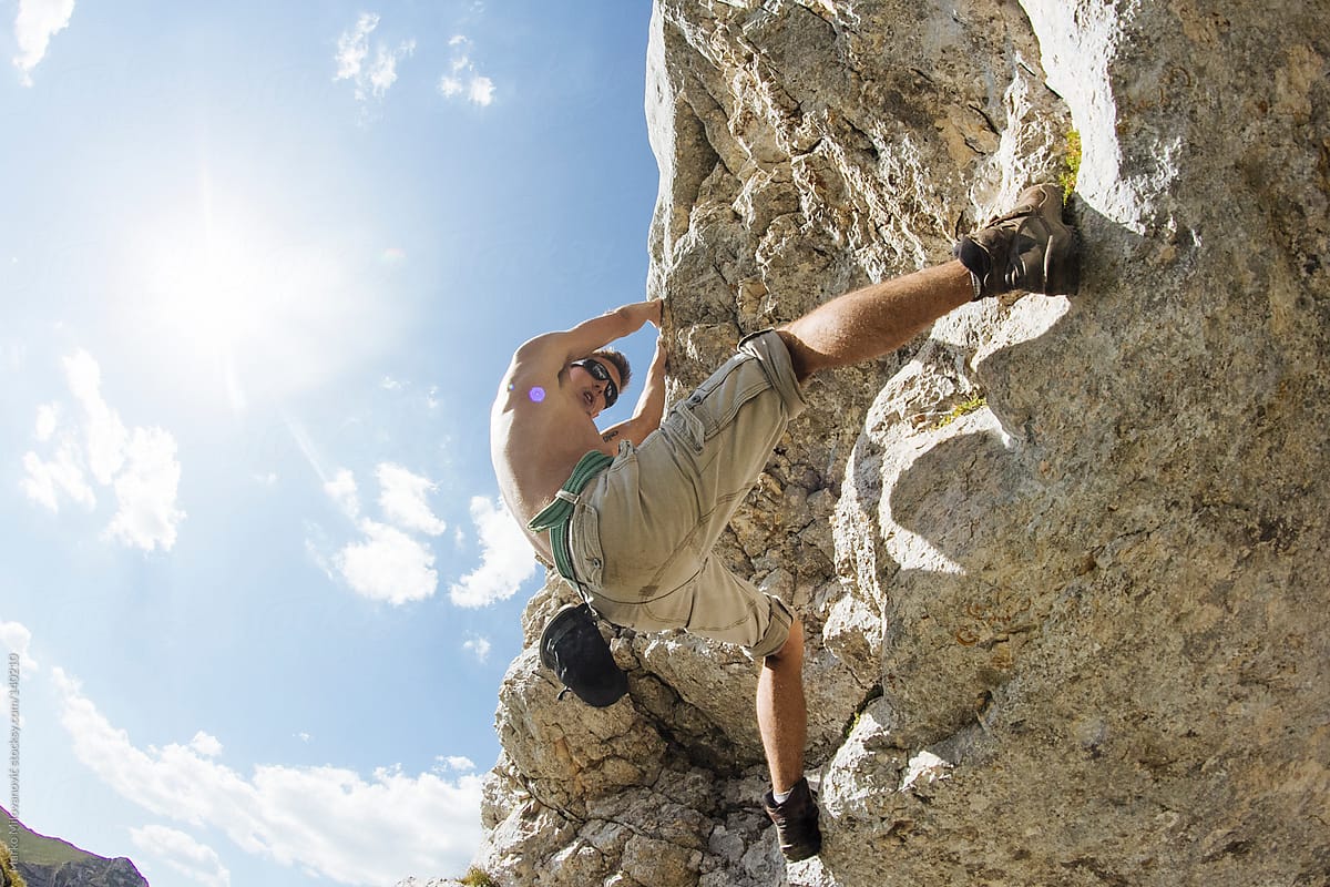 Young man climbing natural rock
