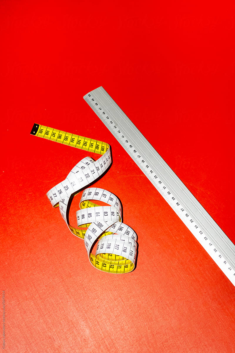 Measurement tape with hard direct flashlight on a coloured background