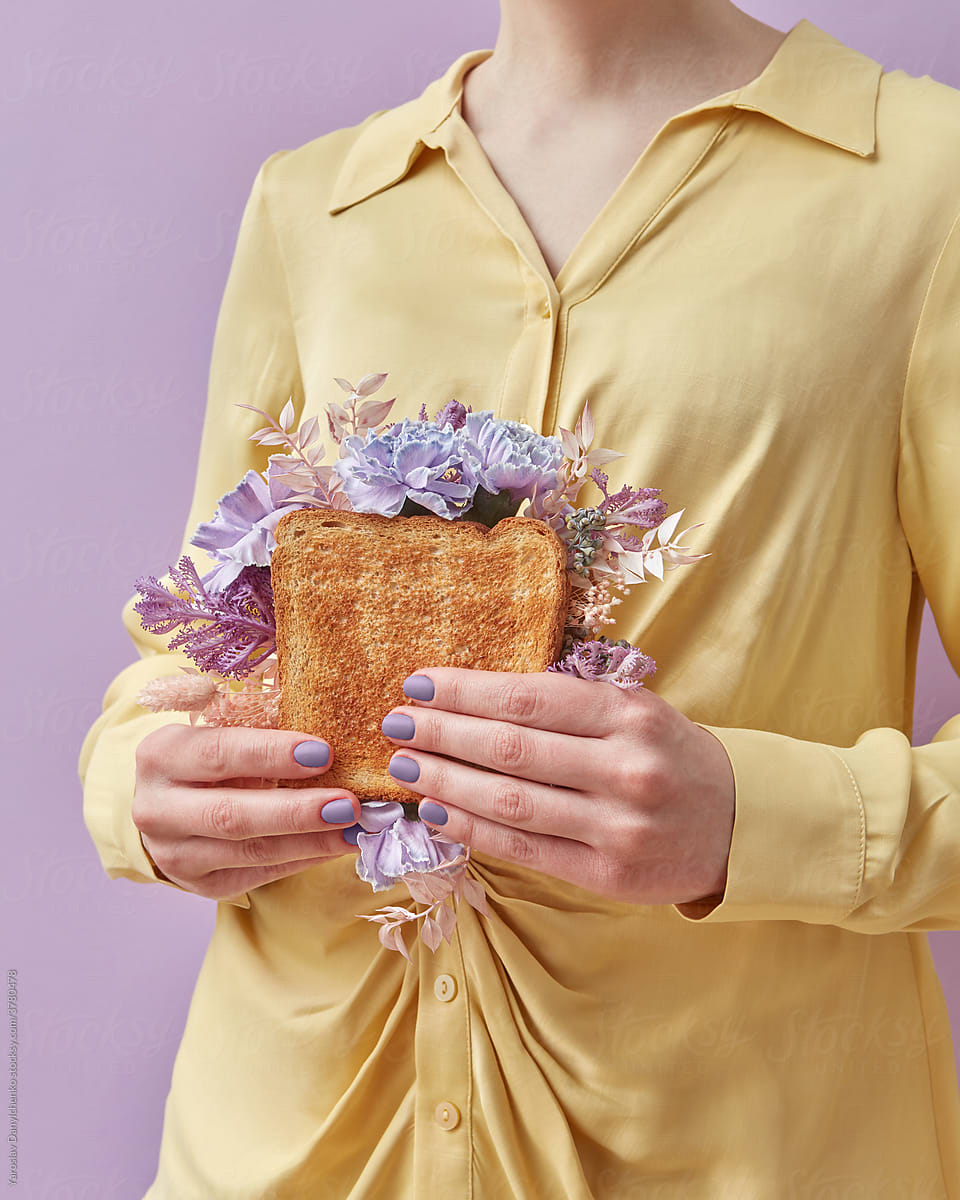 Woman holding sandwich with purple flowers