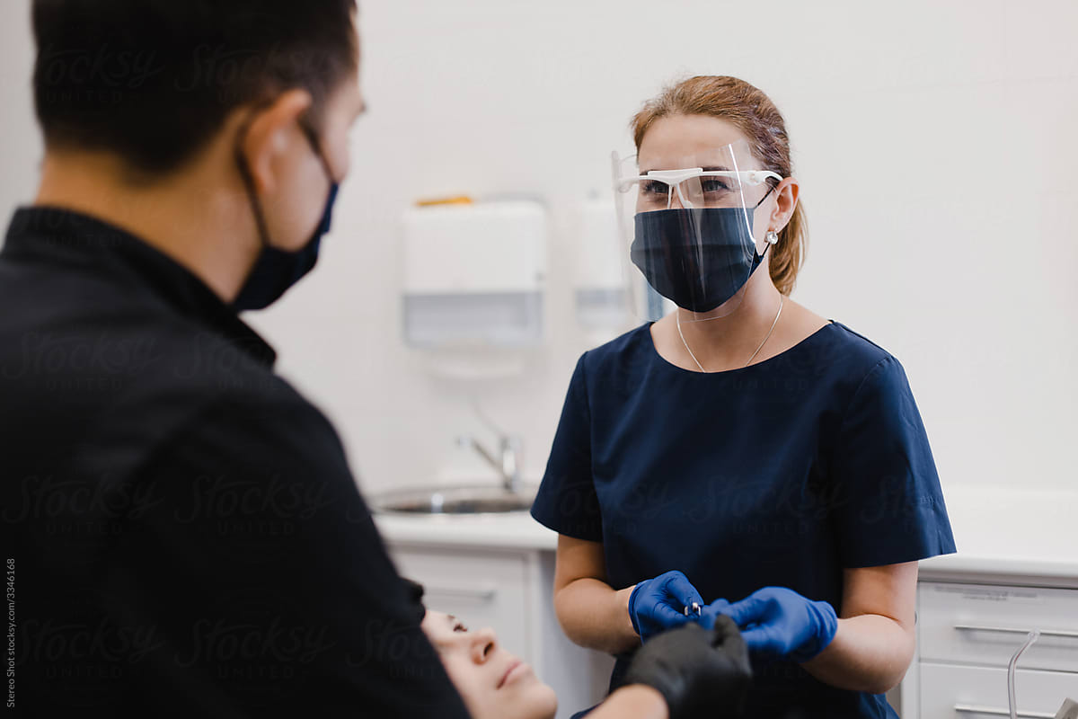 Female assistant talking with dentist during appointment