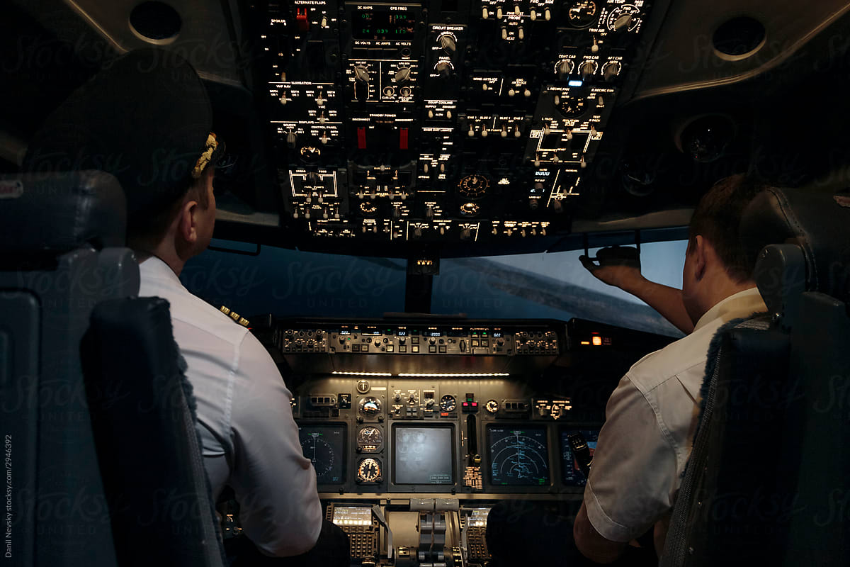 Pilots in aircraft cockpit controlling flight