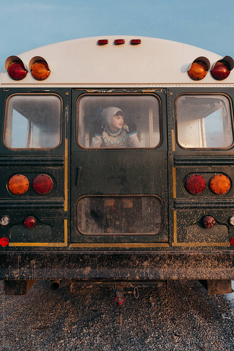 A young boy playing on a school bus