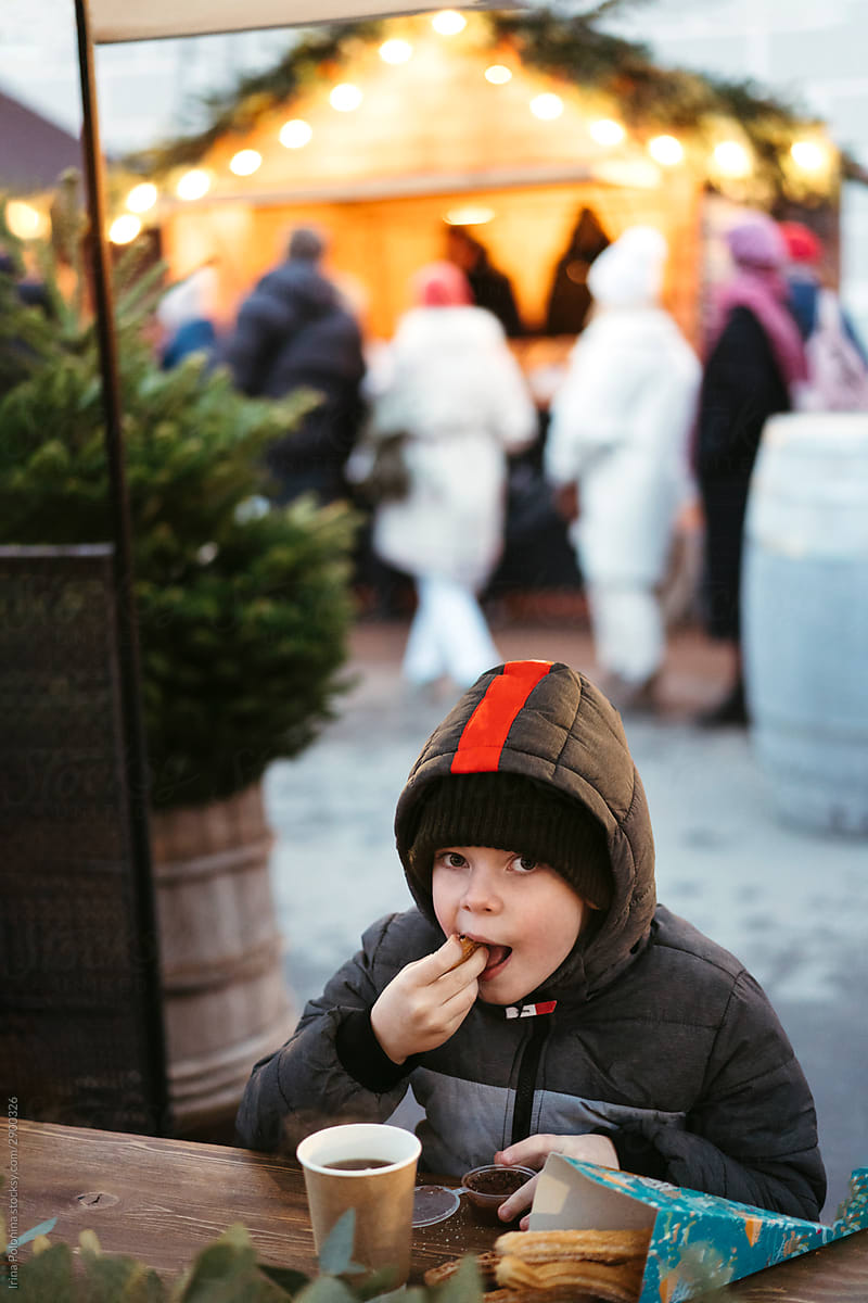 A young boy at a street Christmas market.