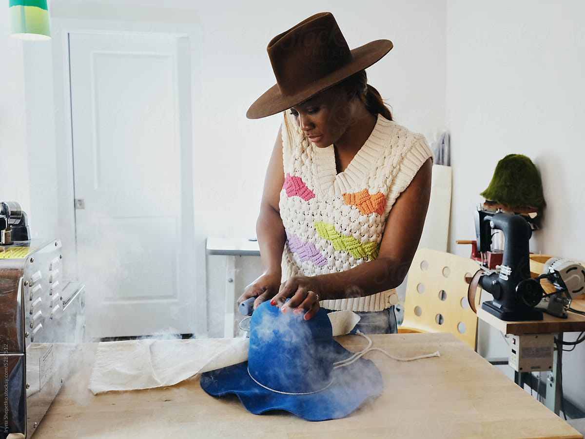 African American Woman Artisan steaming a hat in the workshop