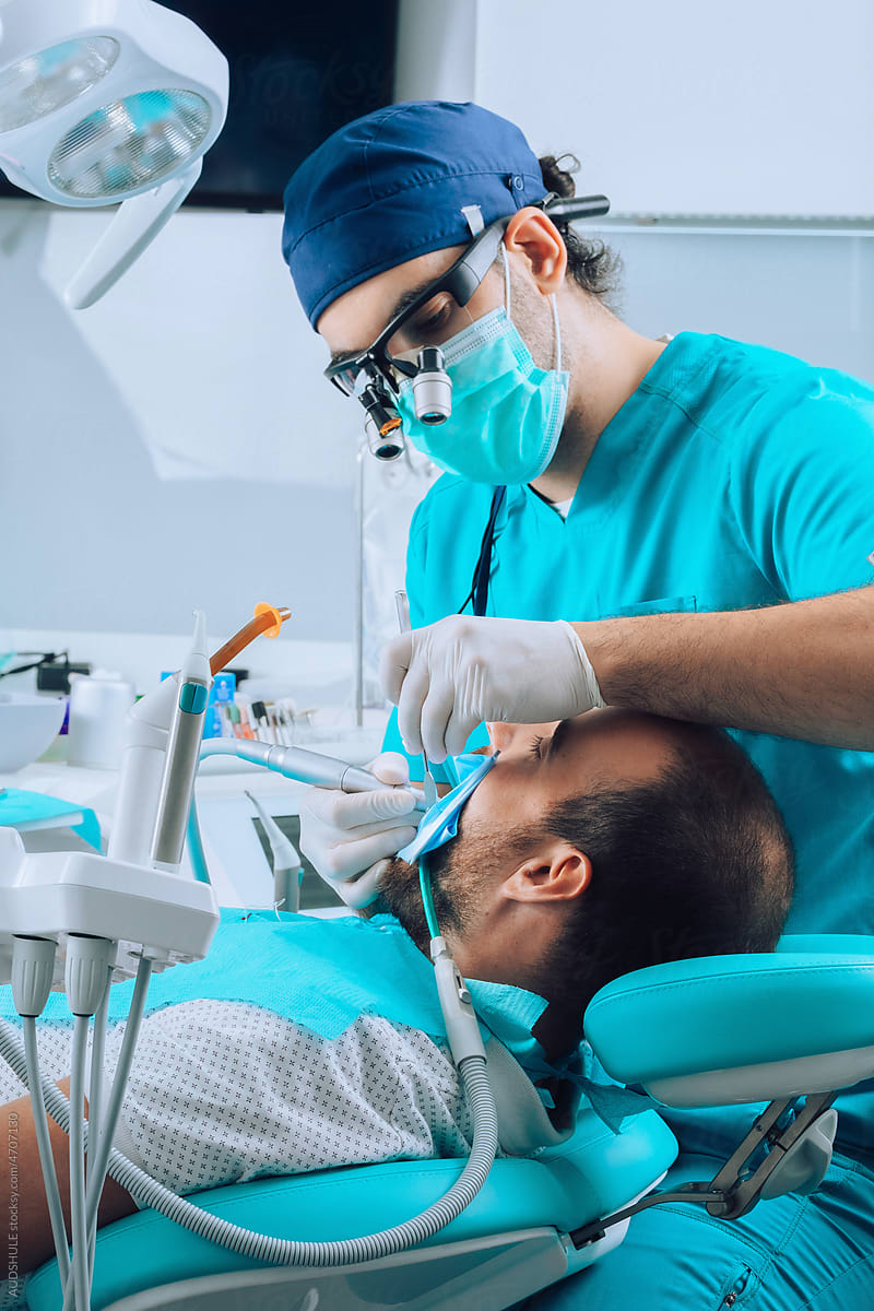 Dentist with instruments and patient during anesthesia