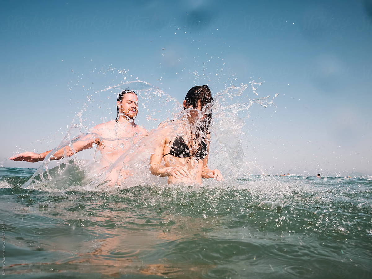 Couple Playing In The Water By Stocksy Contributor Simone Wave Stocksy 