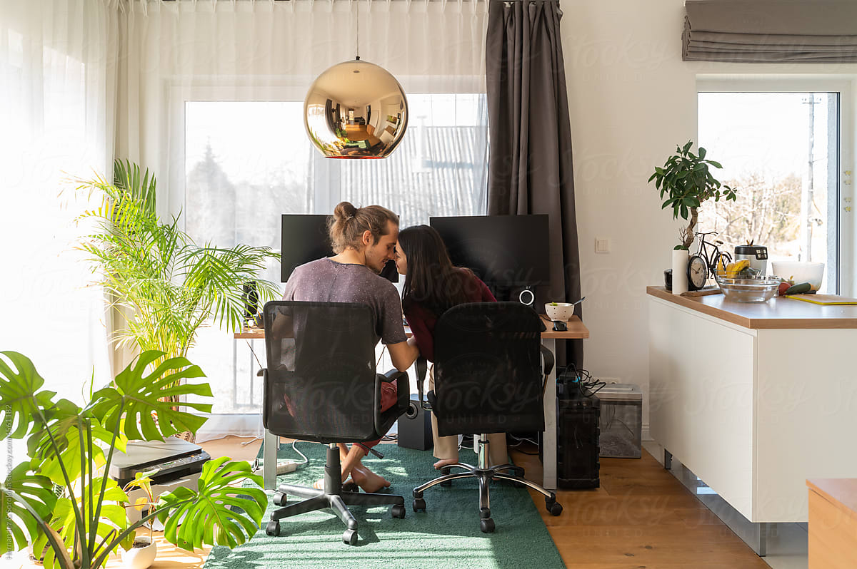 Couple Kissing While Working From Home