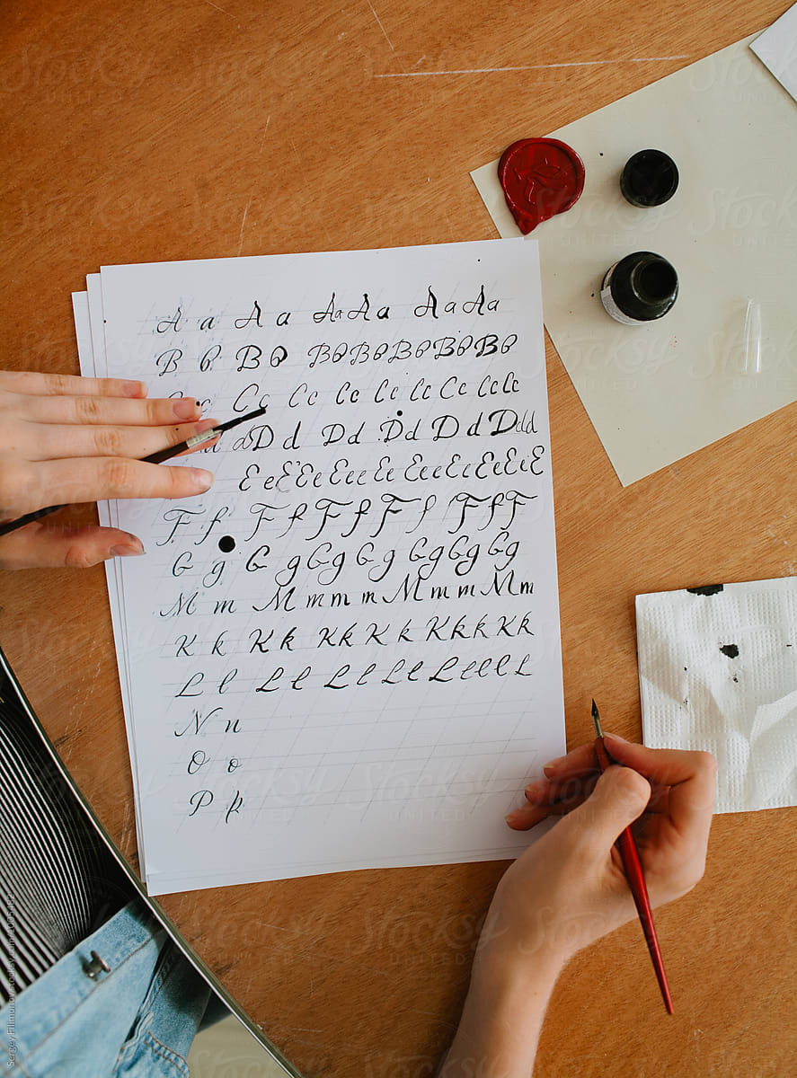 Person writing  with straight calligraphy pen