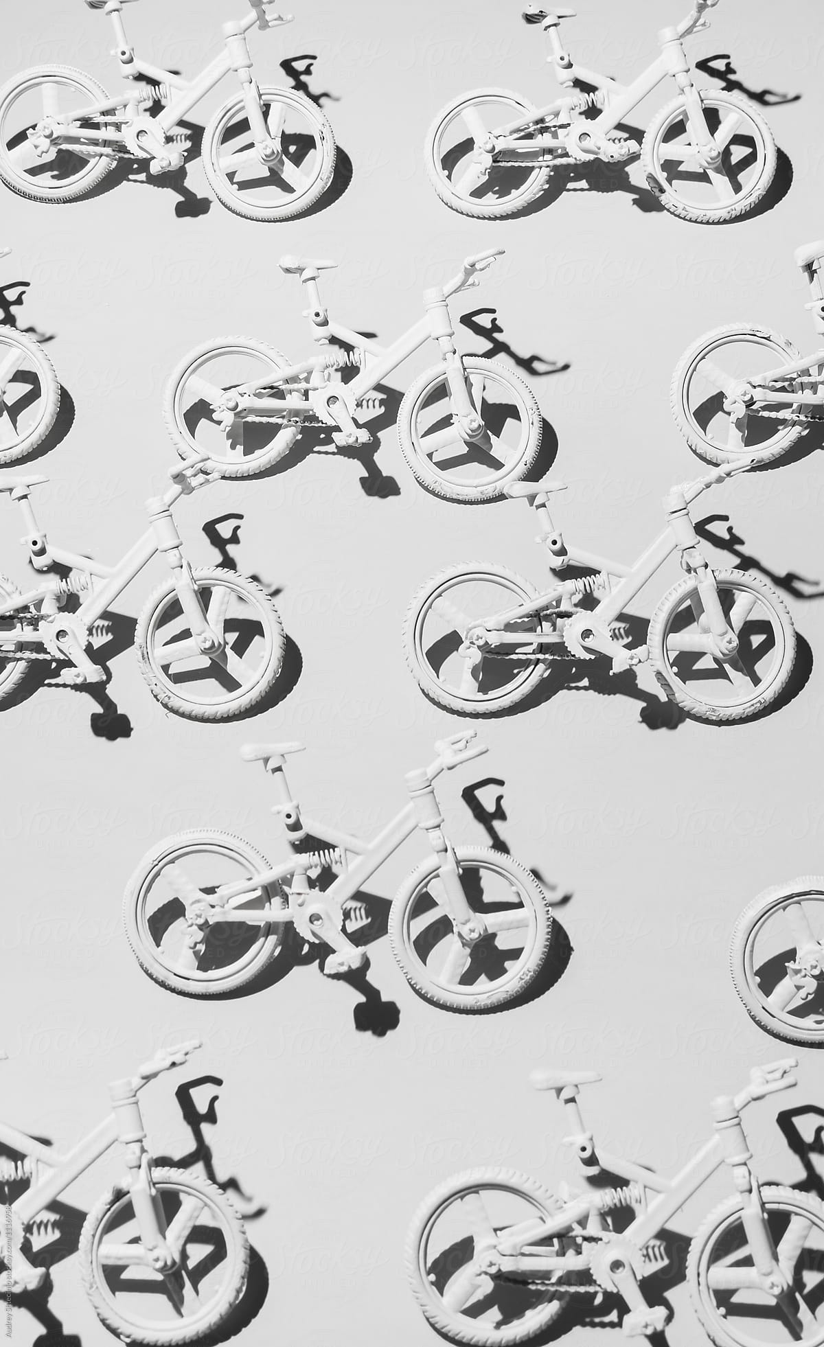 White bicycle miniatures on white background.