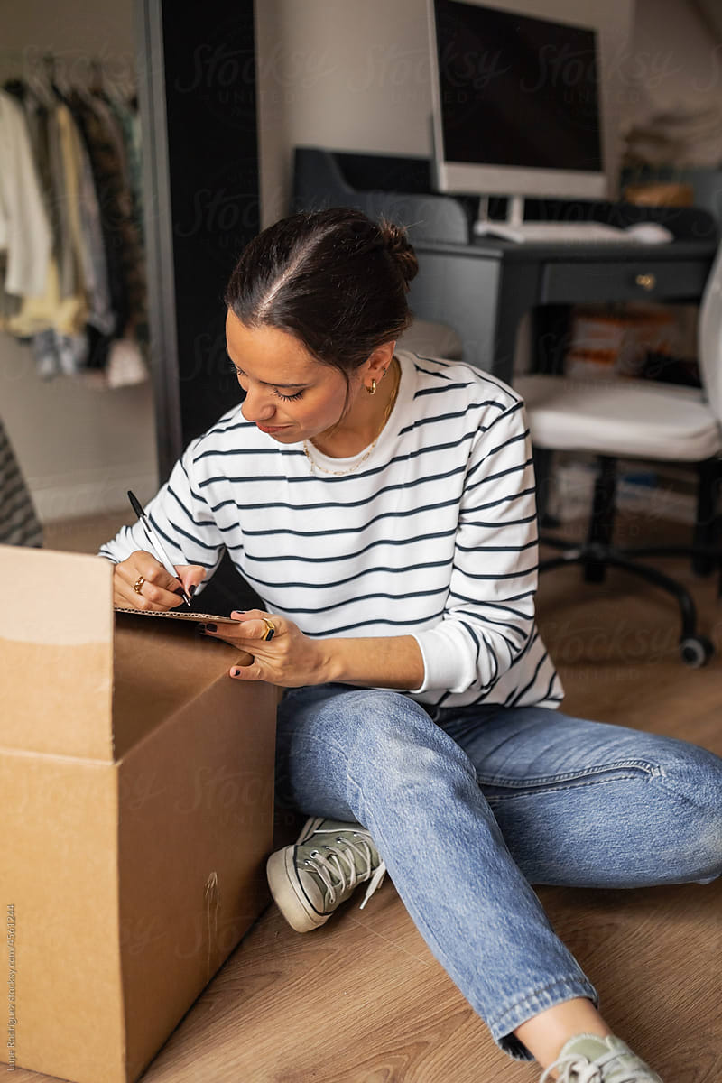 Young woman with a moving box at home