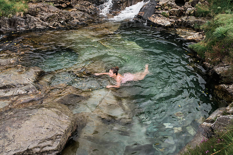 young woman swimming a water pool in the mountains of Wales