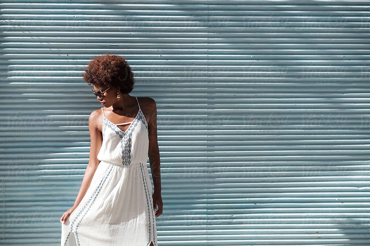 Beautiful Black Woman With Afro Hairstyle Wearing White Sundress Del Colaborador De Stocksy