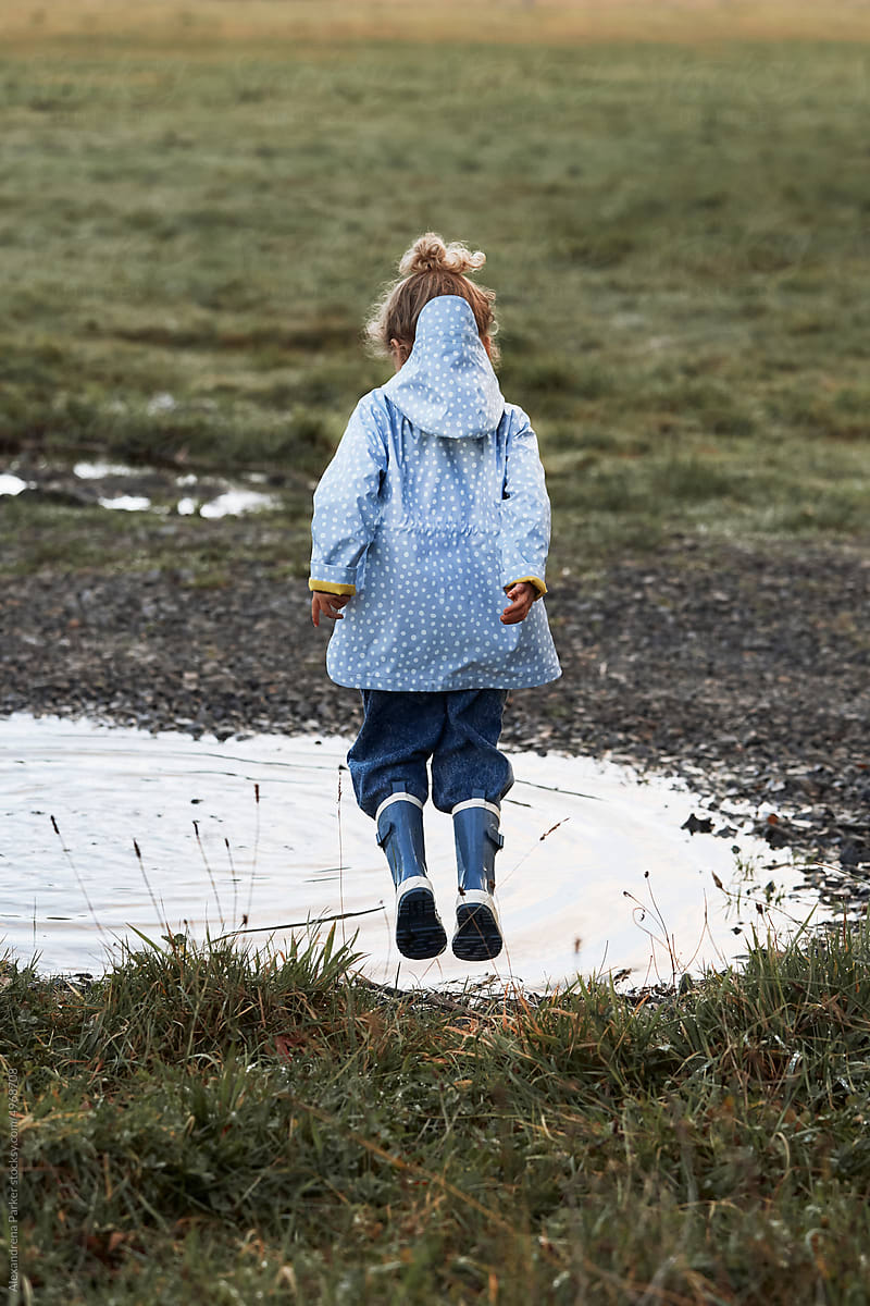 Little girl in muddy puddles