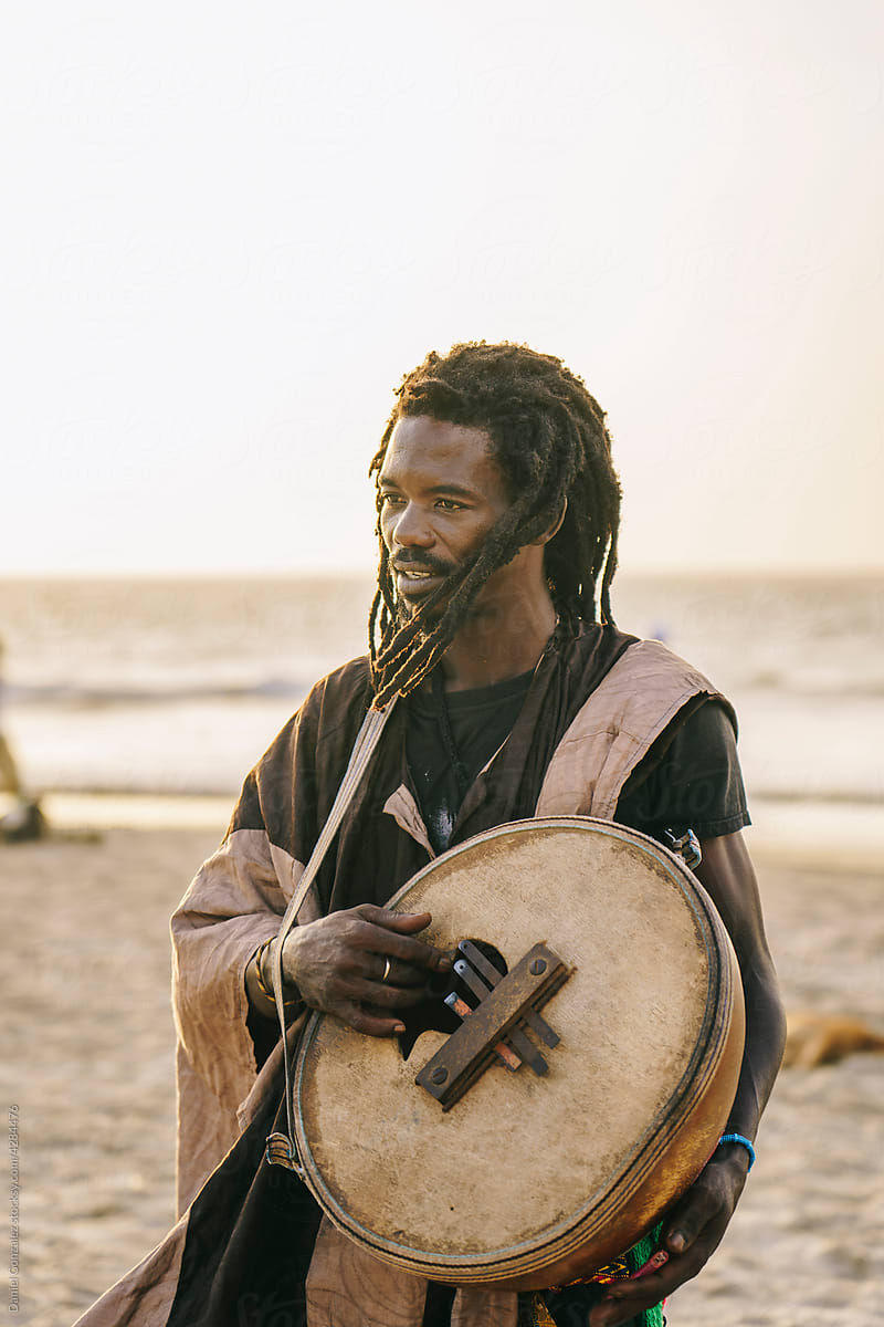 Black man standing with gongomah instrument