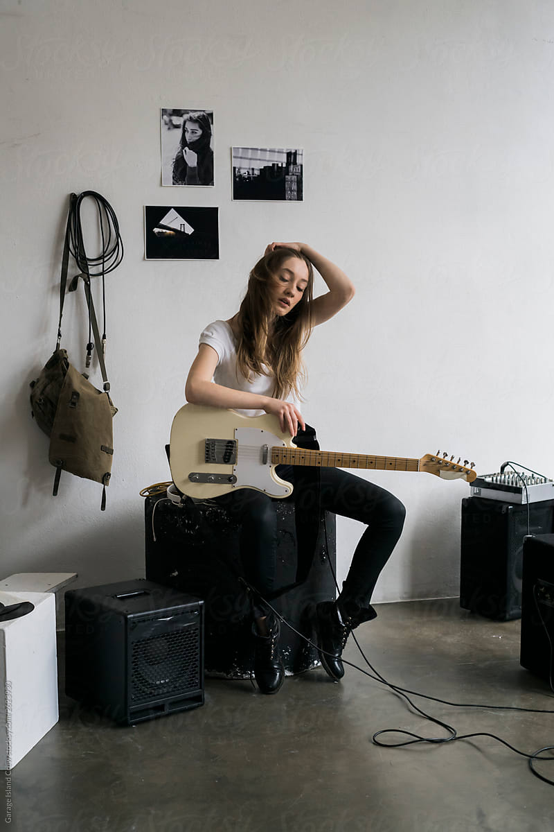 Woman with guitar in rehearsal room