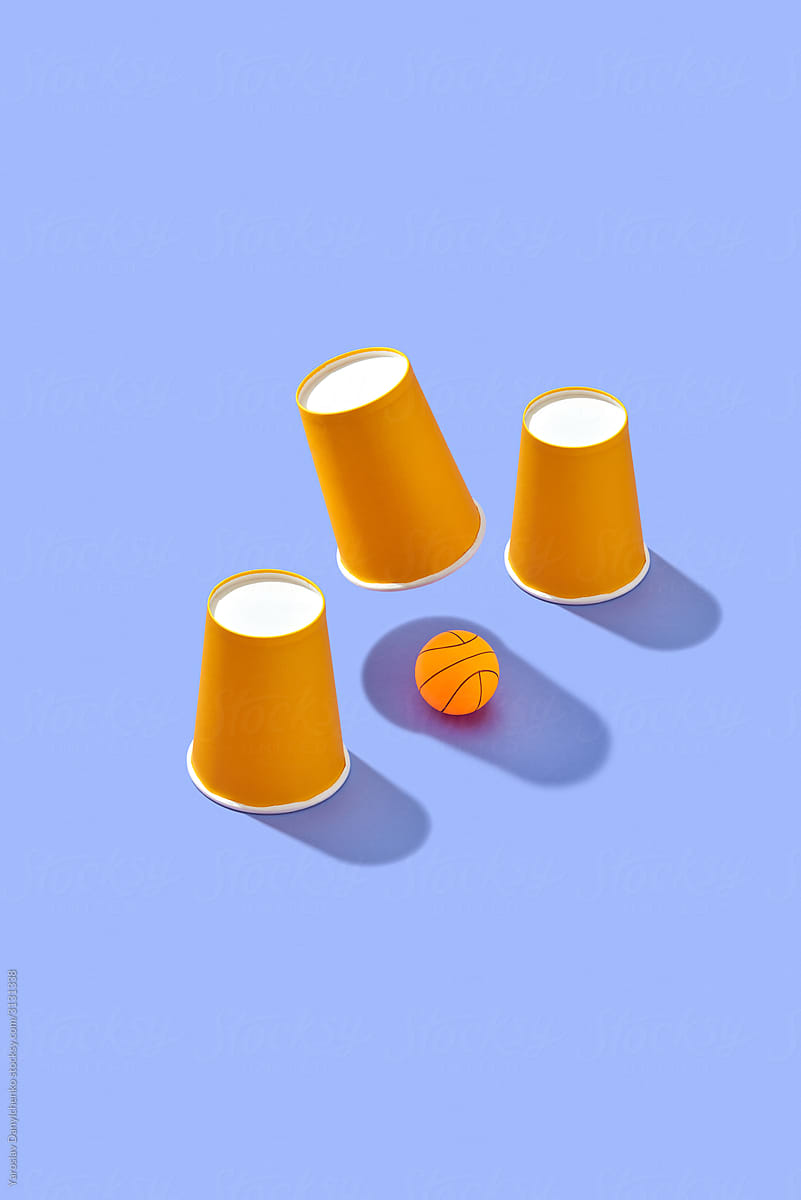 Shell game with paper cups and ball.