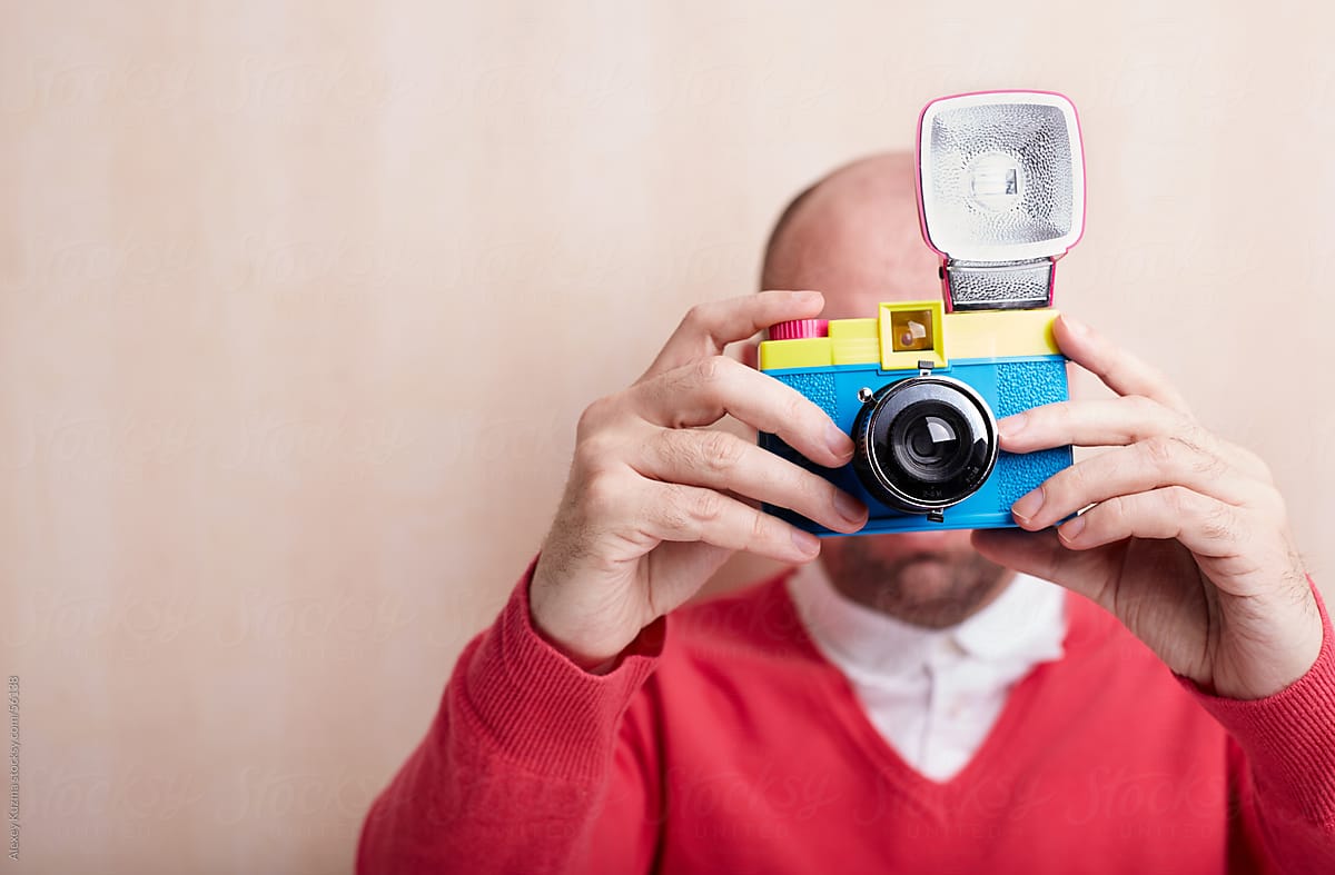 photographer holding toy plastic camera with flash