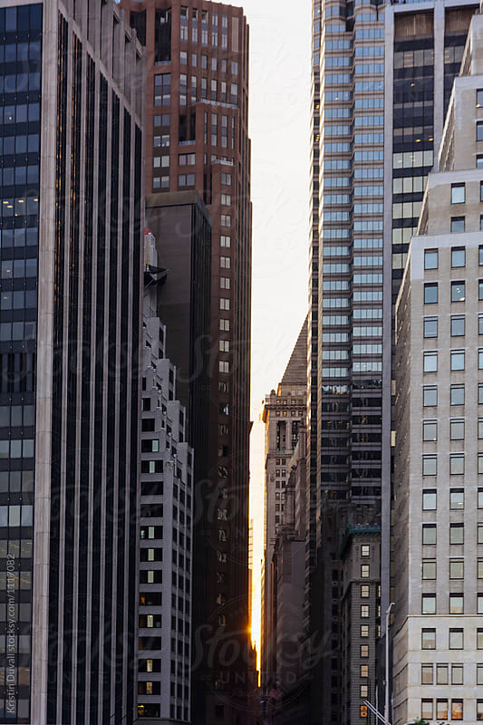 Sun setting behind buildings. New York City