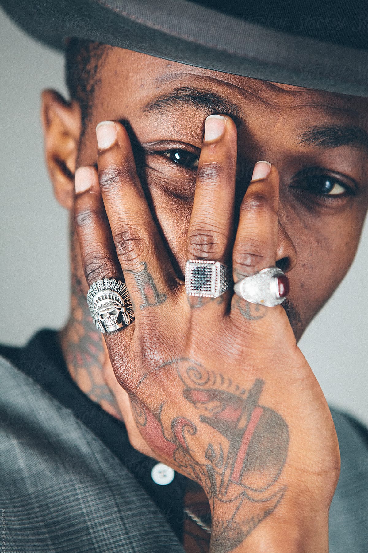 Close up of a stylish black man wearing rings on a tattooed hand Stock  Photo | Adobe Stock