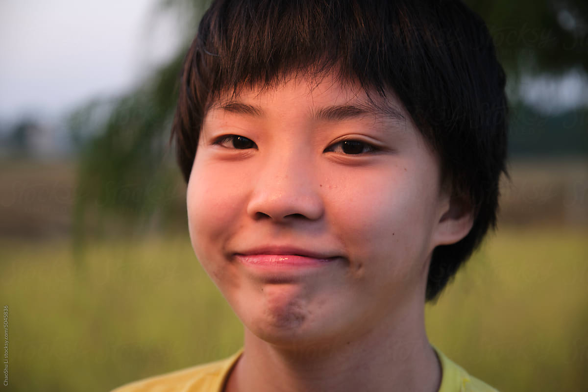 Closeup portrait of a young Asian girl next to a rice field
