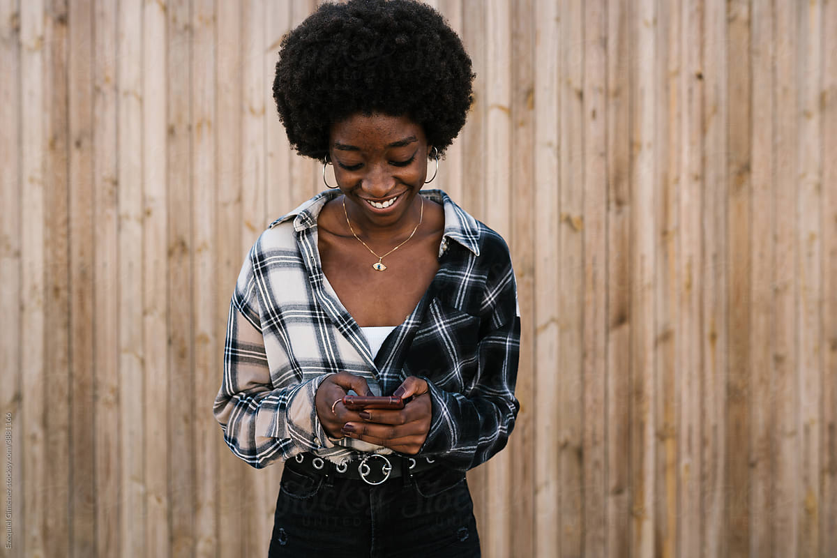 Black woman with afro hair using a cell phone