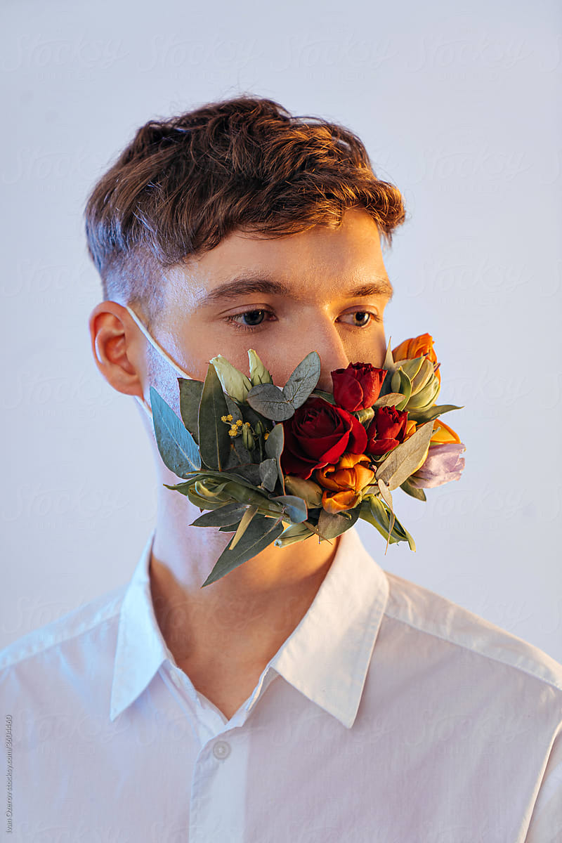a young man in a flower mask looks away