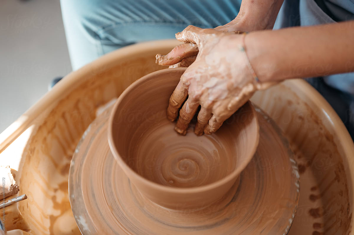 Potter making vase from clay