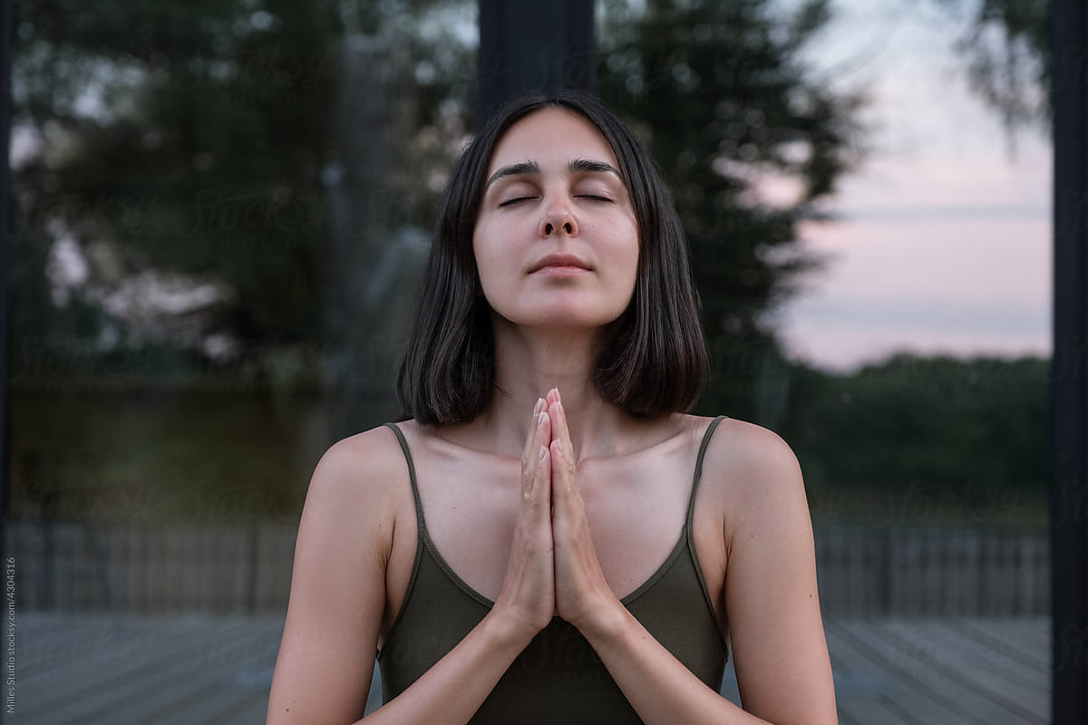 Brunette meditating with clasped hands