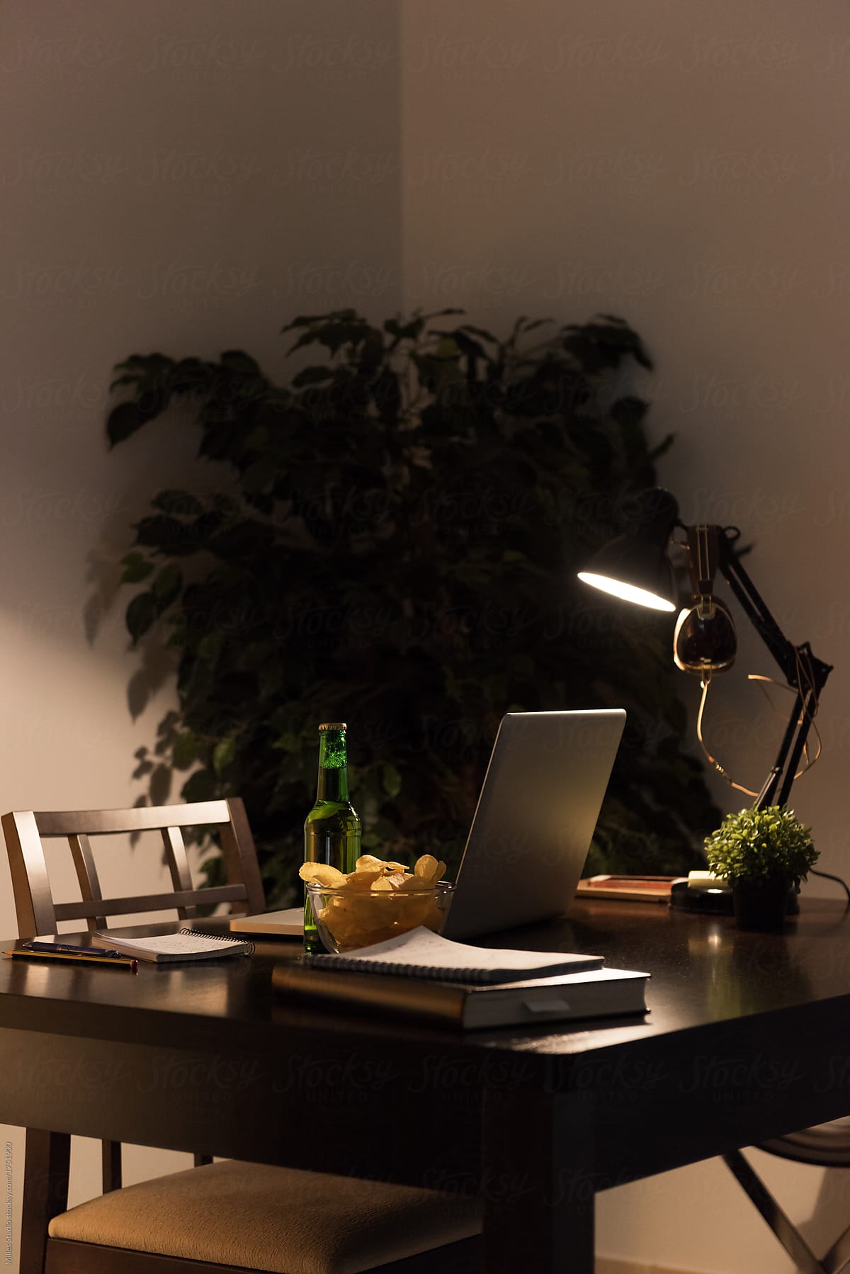 Lamp illuminating table with snacks and laptop
