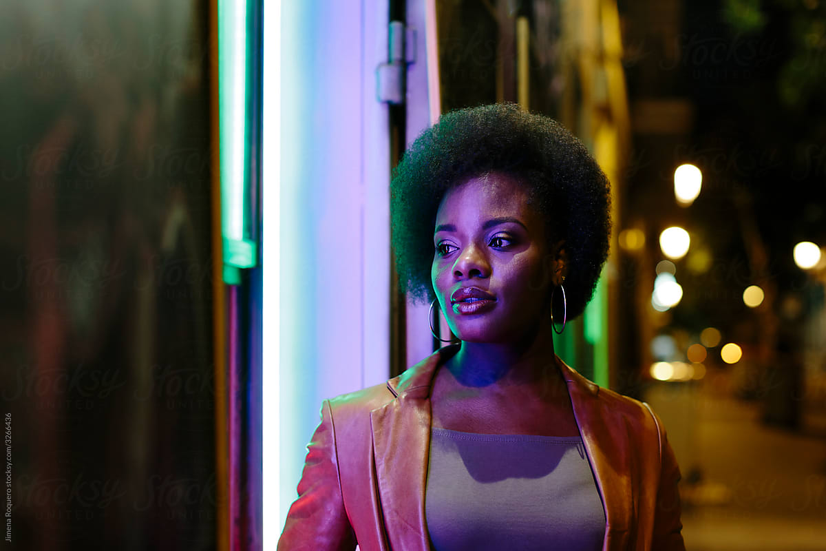 Portrait of attractive Woman with afro hair at night in the street