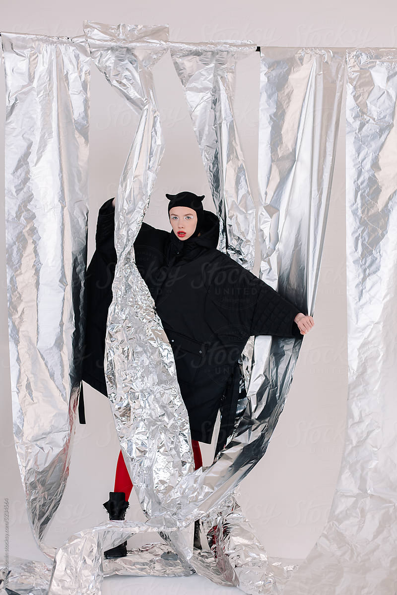 Woman in Halloween costume standing at foil curtains