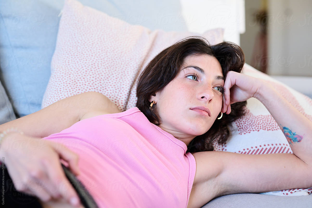 Woman lies on couch watching TV