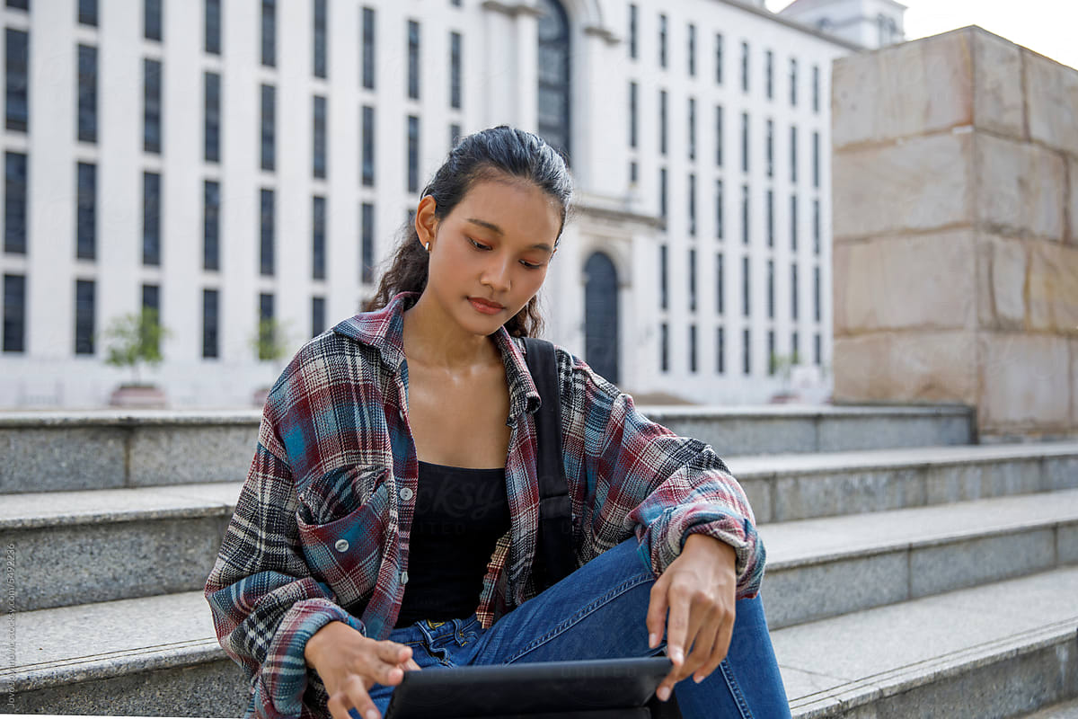 High school girl student using digital tablet at university campus