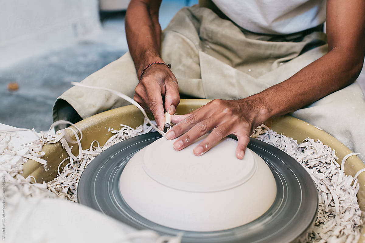 Closeup of Artisan Potter\'s Hands Making Plate on Flywheel