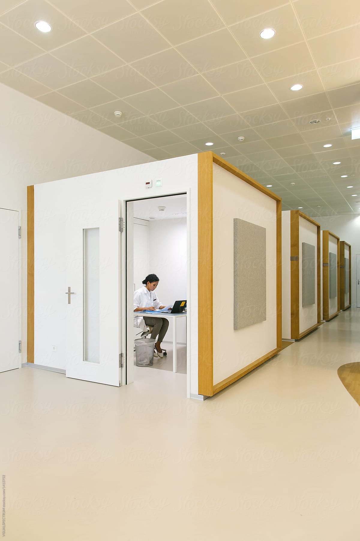 Modern Clinic - Female Doctor Doing Paperwork in White Office Cubicle