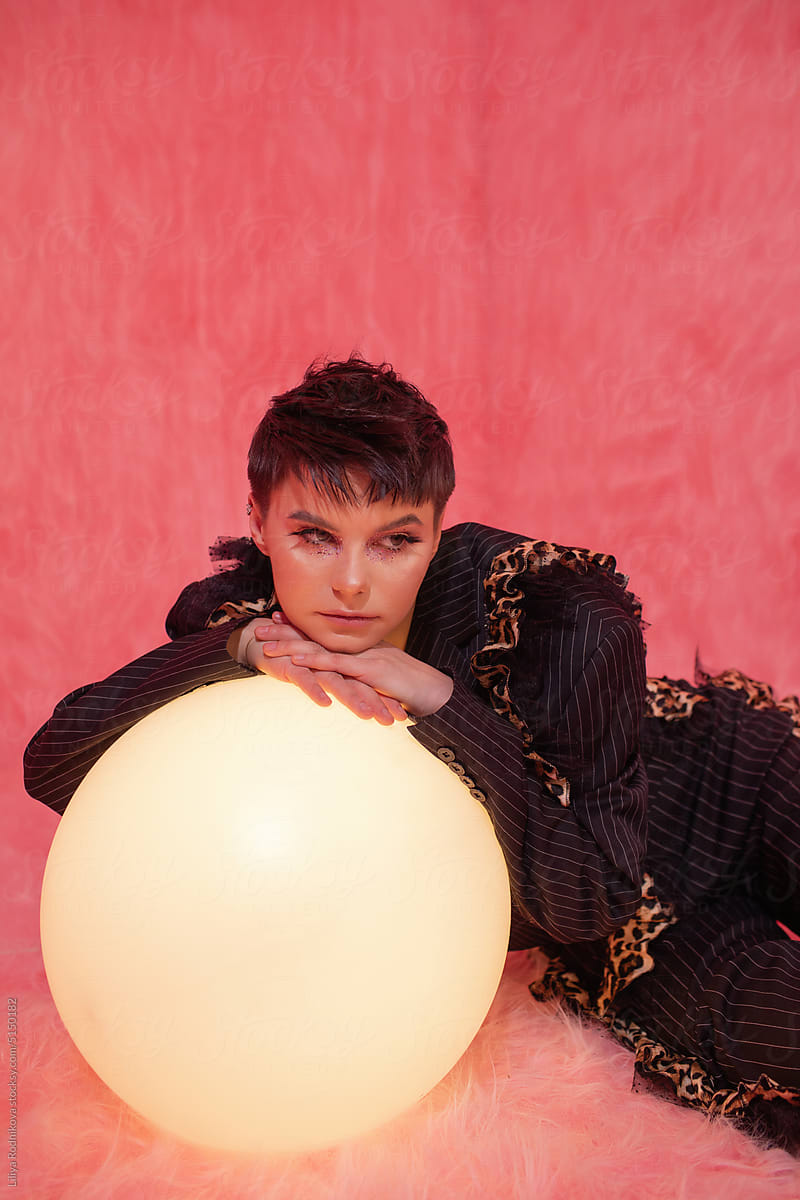 Pensive woman with short hair leaning on light globe