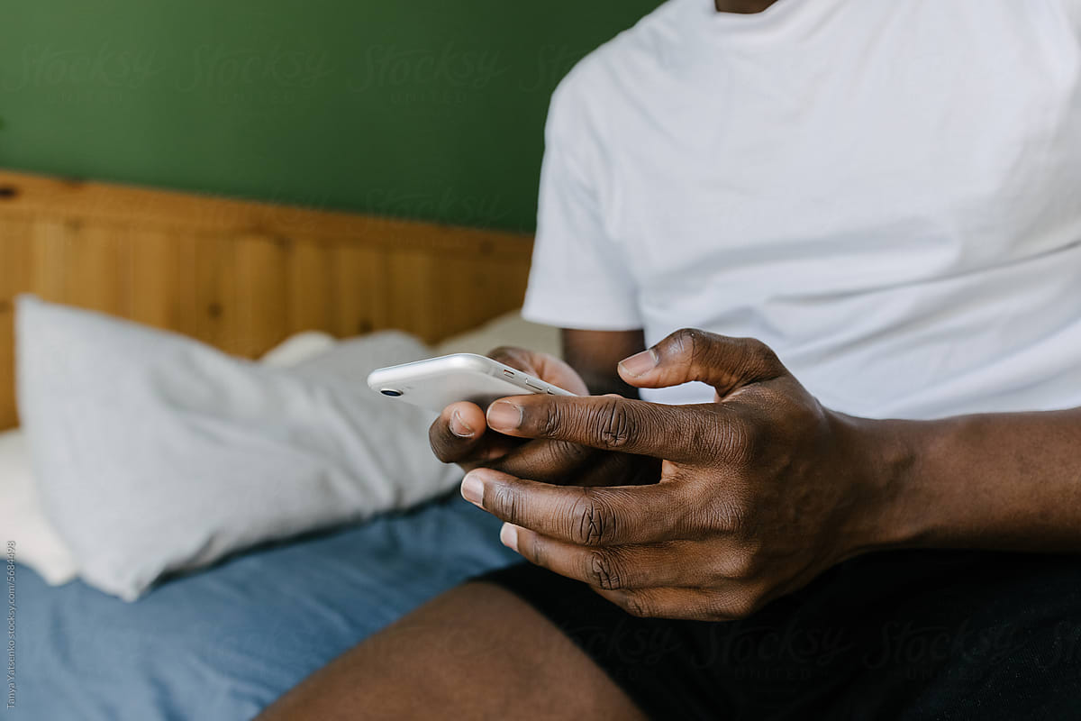 A man with a mobile phone in bed