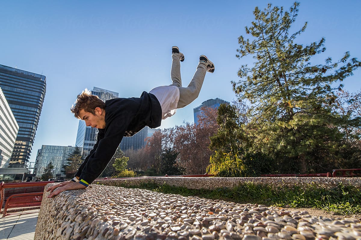 Man making a leap over a wall during a parkour training in a city