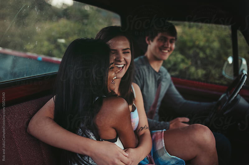Young friends enjoying summer road trip together in old truck