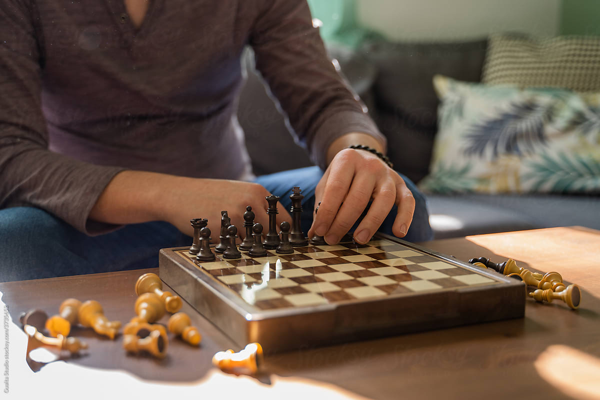Detail of chess board with Man playing chess at home